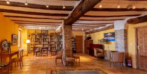 un soggiorno con biblioteca, sedie e tavoli di Hotel Rural Mas Fontanelles a Biar