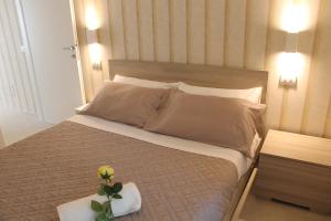 a bedroom with a bed with a flower on it at Soffio del mare in Lido di Fermo