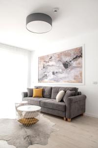 Sala de estar con sofá gris y mesa en WEST RESIDENCE APARTMENTS, en Timisoara