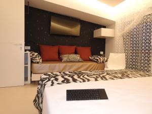 a bedroom with a bed with a laptop on it at Hedoné Design Experience B&B in Agrigento