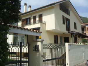 a white house with a gate and a fence at B&B Oro Puro in Fondi