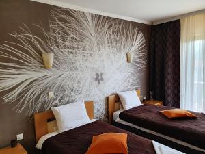 a hotel room with two beds and a mural on the wall at Kompleks Fontana in Vladičin Han