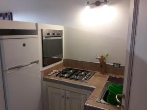 a kitchen with a stove and a refrigerator and a sink at IL TEATRO ALLOGGI in Terni