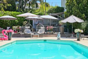 a swimming pool with chairs and umbrellas at Hôtel La Villa Cap d’Antibes in Juan-les-Pins