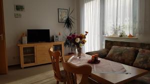 una sala de estar con una mesa con flores. en Ferienwohnung Richter, en Tharandt