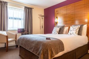 a hotel room with a large bed and a large window at Legacy Preston International Hotel in Preston