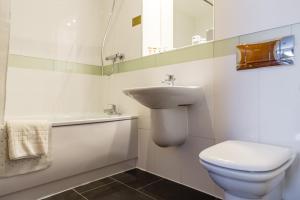 a white toilet sitting next to a sink in a bathroom at Legacy Preston International Hotel in Preston