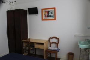 a bedroom with a desk and a chair and a sink at Hôtel le Dervois in Montier-en-Der