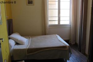 a small bedroom with a bed and a window at Hôtel le Dervois in Montier-en-Der