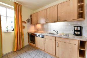 eine Küche mit Holzschränken und einer Spüle in der Unterkunft Seepark Sellin - Apt. 404 in Ostseebad Sellin