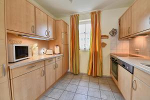 eine kleine Küche mit Holzschränken und einem Fenster in der Unterkunft Seepark Sellin - Apt. 404 in Ostseebad Sellin + 8 Fotos