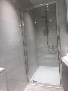 um chuveiro com uma porta de vidro na casa de banho em Tuppenhurst Barn em Rugeley