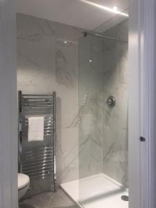 a bathroom with a glass shower with a toilet at Tuppenhurst Barn in Rugeley