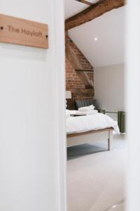 um quarto com uma cama e uma parede de tijolos em Tuppenhurst Barn em Rugeley