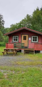 a red house with a picnic table in front of it at Romsdalseggen Camping in Isfjorden