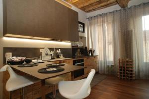 a kitchen with a table and some white chairs at Epicuro guest house in Somma Lombardo