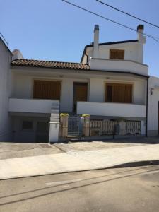 Uma casa branca com uma entrada à frente. em Casa-Lisa seminterrato em Miggiano