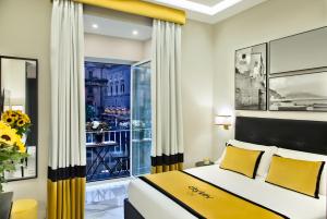 um quarto com uma cama com almofadas amarelas e uma janela em Citykey Napoli - Bed & Breakfast em Nápoles