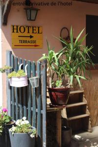 a fence with potted plants in front of a hotel at Hôtel le Dervois in Montier-en-Der