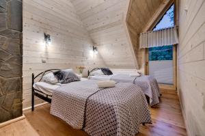 2 Betten in einem Zimmer mit Holzwänden in der Unterkunft Domki U Jadzi in Zakopane