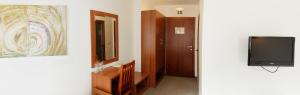 a bathroom with a mirror and a television at Hotel Happy in Dimitrovgrad