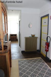 einen Flur eines Hotels mit gelber Tür und Teppich in der Unterkunft Hôtel le Dervois in Montier-en-Der