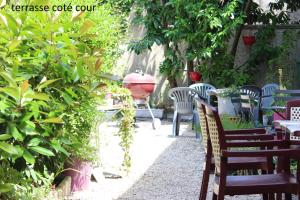 a group of chairs and tables in a garden at Hôtel le Dervois in Montier-en-Der
