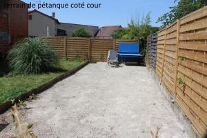 a backyard with a fence and a blue table at Hôtel le Dervois in Montier-en-Der