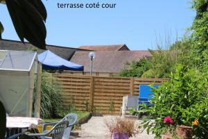 a garden with a fence and tables and chairs at Hôtel le Dervois in Montier-en-Der