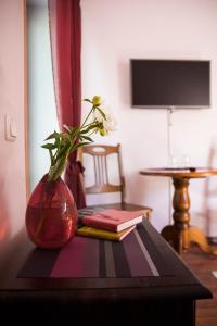 un vase assis sur une table avec des livres dessus dans l'établissement Veski Guesthouse, à Antsla