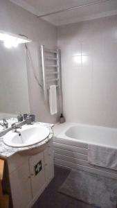 a white bathroom with a sink and a bath tub at Vila Relvão in Vila Franca do Campo