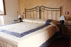 un grande letto in una stanza con due lampade di Agunì Agriturismo e Locanda a Palizzi