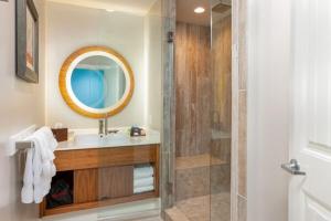 a bathroom with a tub, sink and mirror at Margaritaville Island Hotel in Pigeon Forge