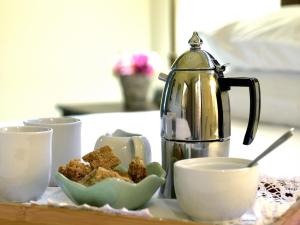 a tea kettle and cups on a table with food at Petit Plaisir Cottage in Franschhoek +18 photos