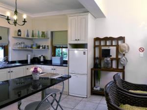 a kitchen with a white refrigerator and a table at Petit Plaisir Cottage in Franschhoek