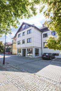 a white building with a car parked in front of it at The Sun by Lubicz in Ustka