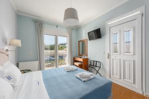a bedroom with a blue bed and a balcony at Pansion Ermioni in Skala
