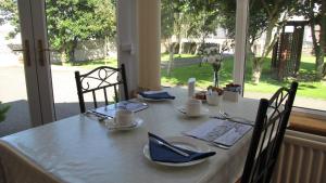 a table with a white table cloth on a table with chairs at Karrawa Guest House in Kirkwall