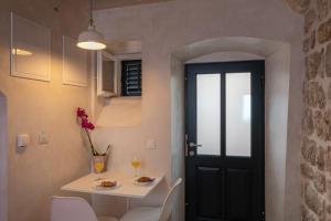 - une salle à manger avec une porte noire, une table et des chaises dans l'établissement Old town Marko, à Dubrovnik