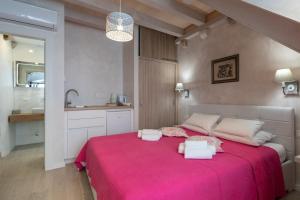 a bedroom with a large bed with a pink blanket at Old town Marko in Dubrovnik