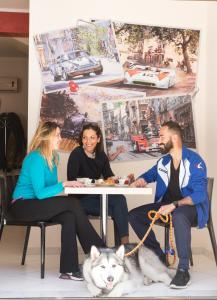 un grupo de personas sentadas en una mesa con un perro en Sosta dei Garibaldini, en Campofelice di Roccella