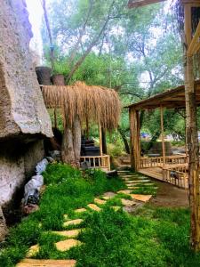 a garden with a wooden pavilion and a tree at Belisırma Cave Hotel in Aksaray