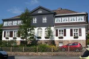 ein Haus mit einem roten Auto, das davor geparkt ist in der Unterkunft FeWo Inge Reiter in Braunlage