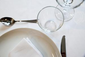 a table with a plate and two glasses and a knife at Hotel Rural Oasibeth in Frómista