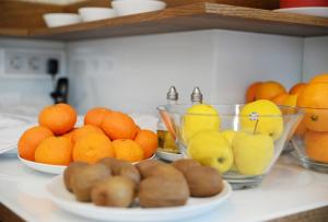 a counter with bowls of oranges and fruit on it at Hotel Rural Oasibeth in Frómista