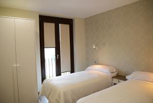 a bedroom with two beds and a window at Hotel Rural Oasibeth in Frómista
