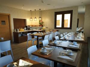 a restaurant with tables and white chairs and a kitchen at Hotel Rural Oasibeth in Frómista
