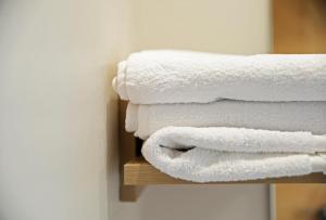 a stack of white towels on a shelf at Hotel Rural Oasibeth in Frómista +19 photos