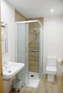 a bathroom with a shower and a toilet and a sink at Hotel Rural Oasibeth in Frómista