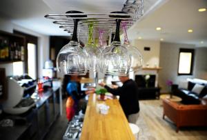 a group of wine glasses hanging over a bar at Hotel Rural Oasibeth in Frómista